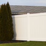 Image of a barn with a primitive star decoration, complimented by a white vinyl privacy vence.