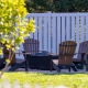 Backyard fire pit set up with white vinyl yard fence