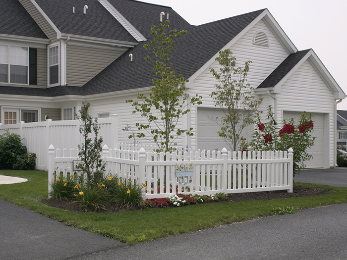 House with white picket fence and floral landscaping
